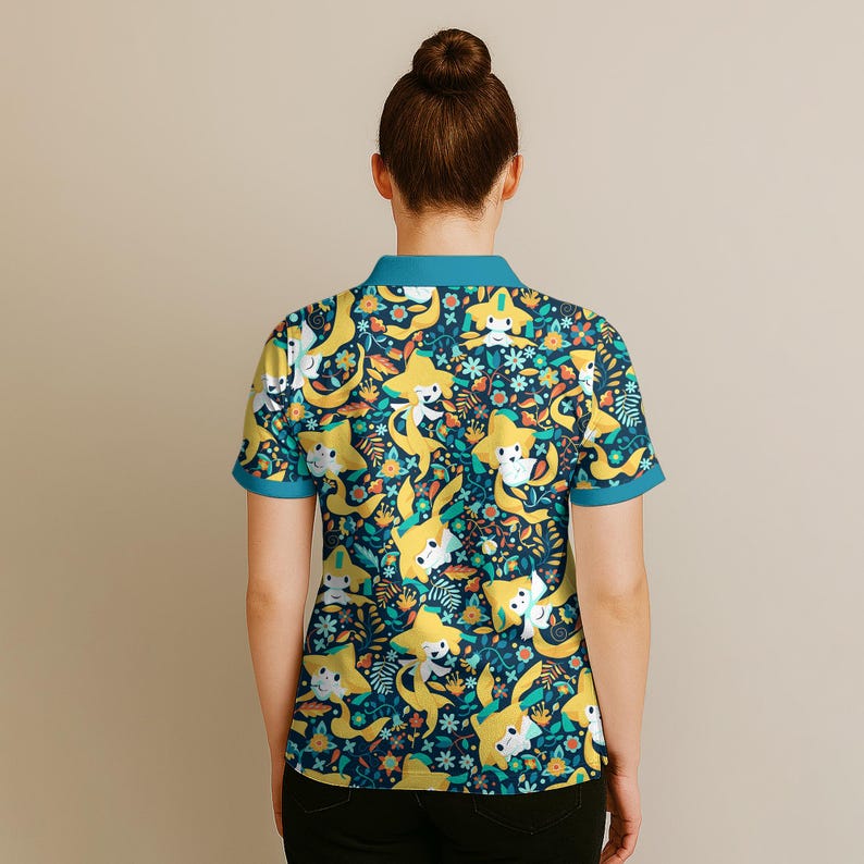 May include: A short-sleeved polo shirt with a whimsical pattern. The shirt features a dark blue background adorned with yellow star-shaped characters, white flowers, and orange and green foliage. The collar and sleeve cuffs are a contrasting teal color.