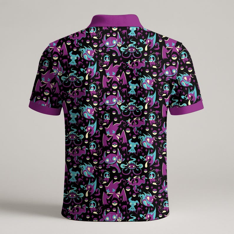 May include: Black polo shirt with a purple collar and sleeve trim. The shirt features a repeating pattern of purple and teal cartoon characters and pokeballs on a black background.