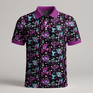 May include: Black polo shirt featuring a repeating pattern of purple, teal, and white cartoon characters. The shirt has a purple collar and sleeve cuffs. The design includes various cartoon monsters on a black background.