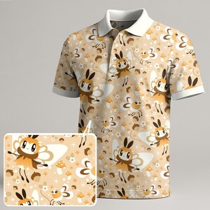 Può includere: Polo beige con un motivo ripetuto di farfalle dei cartoni animati, funghi e ghiande. La camicia ha un colletto bianco e finiture bianche sulle maniche corte. Il design include il numero "3".