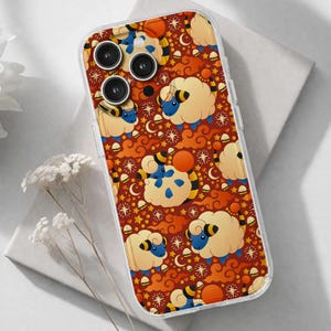 May include: Transparent phone case featuring a repeating pattern of cartoon sheep with blue faces, yellow wool, and orange accents. The background is a dark orange with stars, clouds, and crescent moons.