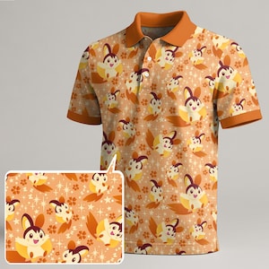 May include: Orange polo shirt featuring a repeating pattern of cartoon characters, flowers, and stars. The shirt has a contrasting orange collar and sleeve cuffs. The design is displayed on the shirt and a smaller inset image.