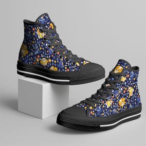 May include: High-top canvas sneakers with a navy blue background and a repeating pattern of cartoon dogs, bones, and paw prints. The shoes have black soles and laces.