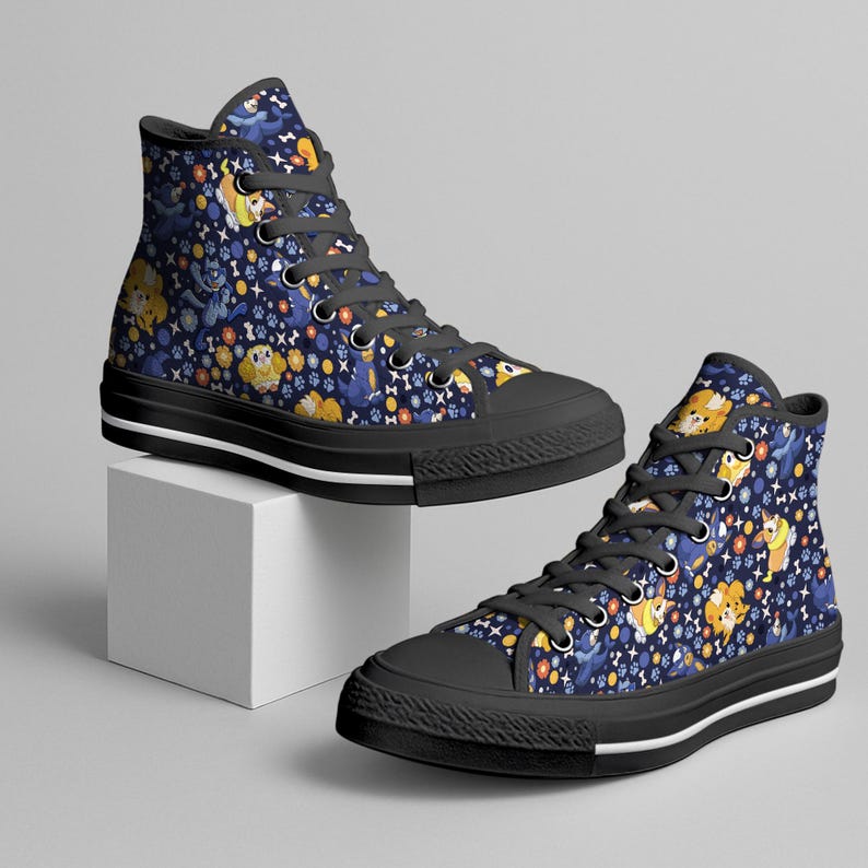 May include: High-top canvas sneakers with a navy blue background and a repeating pattern of cartoon dogs, bones, and paw prints. The shoes have black soles and laces.