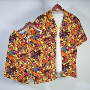 May include: A short-sleeve button-down shirt and matching shorts set featuring an all-over print of orange dragon-like creatures, yellow flames, pink stars, and black sunflowers on a dark background, worn over a plain white t-shirt.