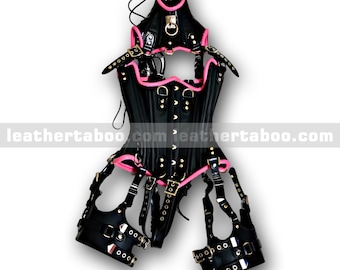 May include: Black leather corset with pink trim and accents. The corset features multiple straps, buckles, and metal hardware. The text "leathertaboo.com" is visible on the bottom of the corset.