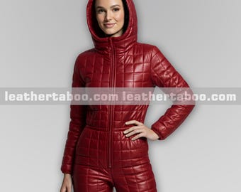 Puede incluir: Mono acolchado de color burdeos con capucha y cremallera frontal. La prenda de una pieza presenta un patrón de diamantes y mangas largas. La dirección del sitio web "leathertaboo.com" está impresa en la parte inferior de la imagen.