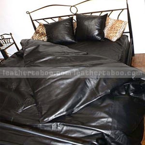 May include: A black leather bed set with a metal frame. The set includes a comforter, two square pillows, and two decorative pillows with a leopard print. The bedding has a shiny, smooth texture.