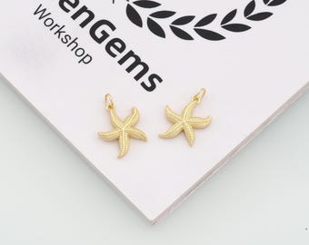 May include: Two gold-toned starfish charms with textured surfaces and small jump rings at the top for attachment. The charms are positioned on a white surface featuring the black printed text "LumenGems Workshop" and a partial laurel wreath graphic.