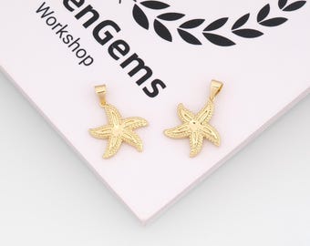 May include: Two gold-coloured starfish pendants. Each pendant has a loop at the top for a chain. The starfish design has textured details. The pendants are on a light pink surface with the text "menGems Workshop".