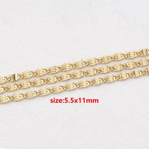 Può includere: Primo piano di tre fili di catena color oro. Ogni maglia ha un design unico e ripetitivo. Il testo "size: 5.5x11mm" è visibile. Le catene sono probabilmente per la creazione di gioielli o l'artigianato.