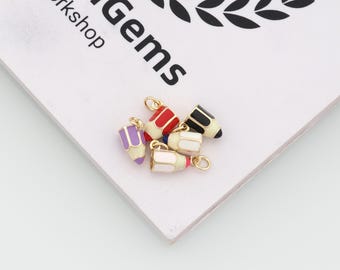 Può includere: Una collezione di cinque ciondoli a forma di matita con anellini in metallo dorato. Ogni ciondolo è rifinito con smalto colorato nelle tonalità viola, rosso, nero, bianco e rosa, progettato per assomigliare a strumenti di scrittura.