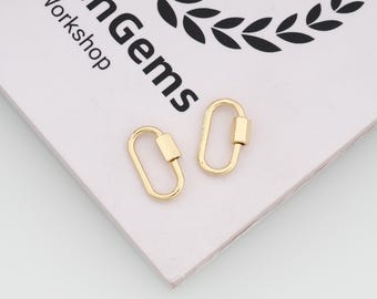 May include: Two gold-toned oval carabiner clasps with a spring-loaded gate mechanism. The clasps are positioned on a white card featuring a black laurel wreath graphic and the text "henGems Workshop" printed in black ink on the surface.