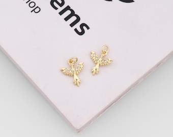 May include: Two gold-toned metal charms shaped like birds with outstretched wings, each featuring small embedded clear stones along the wings. Each charm includes a small circular jump ring at the top for attachment to jewelry or accessories.