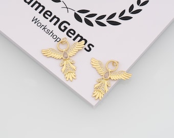 May include: Two gold-colored angel-shaped pendants with crystal accents. The pendants have outstretched wings and a central crystal. The image also shows the text "LumenGems Workshop".
