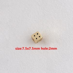 May include: A gold-colored die with black dots, size 7.5x7.5mm, and a 2mm hole. The die is shown against a white background. The text "size:7.5x7.5mm hole:2mm" is visible.
