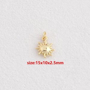 Peut inclure: Pendentif en forme de soleil doré, avec une boucle pour l'attacher à un collier ou un bracelet. Le soleil a un centre rond avec des rayons pointus. Le texte "size: 15x10x2.5mm" est en rouge. Idéal pour la création de bijoux.