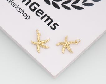 May include: Two gold starfish charms with a textured finish. Each charm has a small loop at the top for attaching to jewellery. The charms are on a white surface with the text "enGems Workshop".