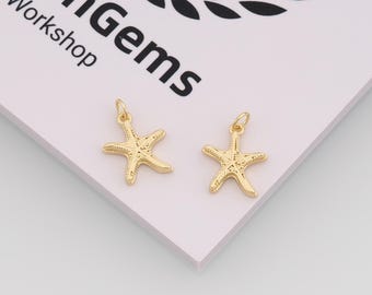 May include: Two gold starfish charms with loops for jewellery making. The charms are on a white surface with the text "enGems Workshop" in black. The starfish have textured details.
