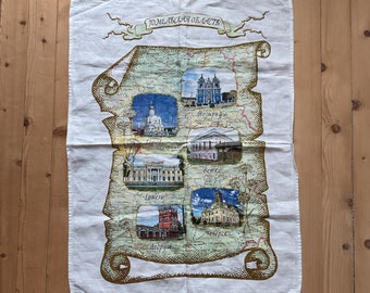 May include: A white tea towel with a map of the Gomel region of Belarus. The map features illustrations of buildings and landmarks from different cities in the region, including Gomel, Vetka, Dobrush, Chechersk, and Turov. The text "Gomel Region" is written in Russian at the top of the map.