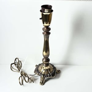 Décoration d&#39;intérieur avec trépied antique en laiton orné, base de lampe de table abîmée