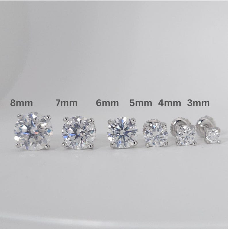 May include: A selection of six diamond stud earrings, varying in size from 3mm to 8mm. The earrings are round-cut with a sparkling appearance, set in a silver or white metal. Sizes are indicated above each earring.