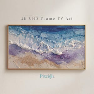 May include: A framed artwork depicting an ocean scene with textured waves in shades of blue, white, and purple. The sandy beach is a light tan color. The text "4K UHD Frame TV Art" is at the top, and the logo "Pixeigh" is at the bottom.