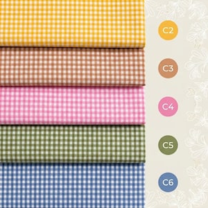 Pode incluir: Cinco amostras de tecido empilhadas com um padr&atilde;o de xadrez vichy pequeno em amarelo, castanho claro, rosa, verde azeitona e azul. &Agrave; direita, cinco etiquetas de cor circulares correspondentes est&atilde;o marcadas com o texto C2, C3, C4, C5 e C6.