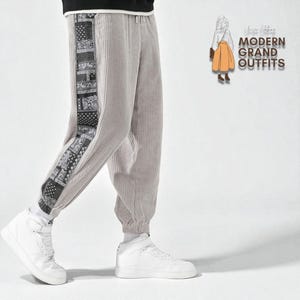 May include: Light gray corduroy pants with a black and white patterned side panel. The pants have a drawstring waist and are cuffed at the ankles. The pants are paired with white high-top sneakers. The text "MODERN GRAND OUTFITS" is visible in the background.