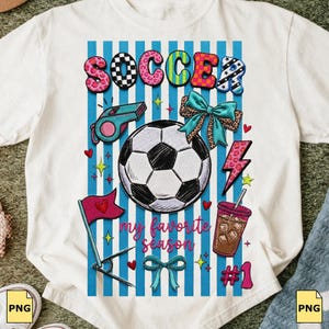 Peut inclure: T-shirt blanc avec un motif sur le thème du football. Le design comprend le mot "SOCCER" en lettres colorées, un ballon de football, un sifflet, des nœuds, des cœurs, un éclair, un drapeau, une boisson et le texte "my favorite season".