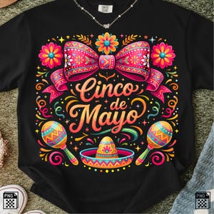 Peut inclure: Un t-shirt noir avec une impression graphique colorée portant le texte Cinco de Mayo au centre. Le motif comprend un grand nœud rose, des fleurs vives, deux maracas et un sombrero, le tout dans des tons éclatants d'orange, de jaune et de bleu.