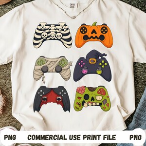 Peut inclure: T-shirt blanc avec six motifs de manettes de jeu vidéo sur le thème d'Halloween. Les manettes incluent un squelette, une citrouille, une momie, une sorcière, un vampire et un zombie. Le texte "PNG COMMERCIAL USE PRINT FILE PNG" est en bas.