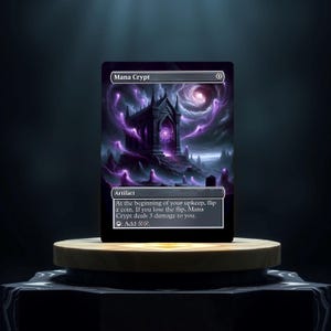 Può includere: Una carta di Magic: The Gathering chiamata "Mana Crypt". È una carta artefatto con uno sfondo nero e viola. La carta mostra un edificio scuro e gotico con un grande portale luminoso. Il testo sulla carta recita: "All'inizio del tuo mantenimento, lancia una moneta. Se perdi il lancio, Mana Crypt ti infligge 3 danni. Aggiungi ".
