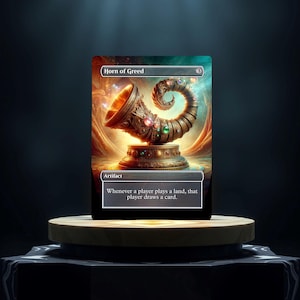 May include: A gold and brown artifact card with the text "Horn of Greed" and the text "Artifact" below it. The card has an illustration of a golden horn with gems on it.