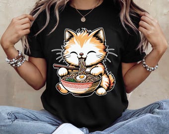 May include: Black t-shirt featuring a cartoon cat enjoying ramen. The orange and white cat is depicted with chopsticks, eating noodles from a decorative bowl. The design is a playful illustration, perfect for cat lovers and those who enjoy Japanese cuisine.