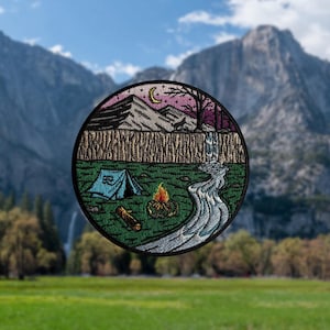 May include: Embroidered patch featuring a camping scene. The design includes a blue tent, campfire, and a flowing river. The upper portion depicts mountains, a crescent moon, and a tree. The patch is circular with a green, brown, and blue color scheme.
