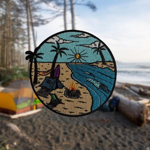 May include: Embroidered patch depicting a beach camping scene. The circular design features a blue sky, palm trees, a tent, campfire, surfboard, and ocean waves. The patch is edged in black.