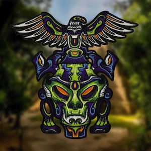 Pode incluir: Patch bordado com um design estilizado de caveira, em cores vibrantes verde, roxo e laranja. Uma águia com as asas abertas no topo. O patch tem um design detalhado e intrincado.