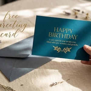May include: A dark teal rectangular greeting card with gold foil text that reads HAPPY BIRTHDAY, A very special year awaits you, filled with joy, wonder, and growth, featuring a gold olive branch illustration and a matching dark teal envelope.