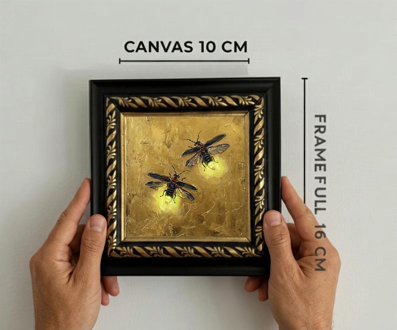 May include: A square painting of two fireflies on a gold background, encased in a black and gold ornate frame. Text indicates a canvas size of 10 cm and a full frame size of 16 cm. The fireflies feature glowing yellow abdomens and dark wings.