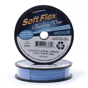 Op de afbeelding: Een spoel blauwe Soft Flex kralen draad, met het label "Tanzanite Soft Flex Beading Wire Original Flex Wire Medium". De spoel is 9 meter lang en heeft een diameter van 0,48 mm. Het is gemaakt in de VS en heeft een treksterkte van 26 pond.