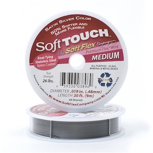 Op de afbeelding: Een spoel met zilverkleurige Soft Touch Premium Flex Wire, met het label "Medium". De draad is 9 meter lang en heeft een diameter van 0,48 mm. Het is gemaakt in de VS en geschikt voor alle soorten kralen.