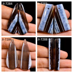May include: Four sets of polished stone pendants featuring banded patterns of translucent light blue and opaque dark brown. Each piece includes a small drilled hole at the top for suspension. The sets are labeled JI-7284, JI-7285, JI-7286, and JI-7288.