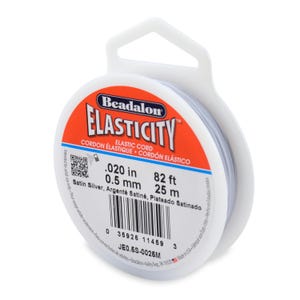 May include: A spool of Beadalon Elasticity satin silver elastic cord. The label reads: .020 in, 25 m, 0.5 mm. The spool is white with a red and white label. The cord is intended for adult use only.