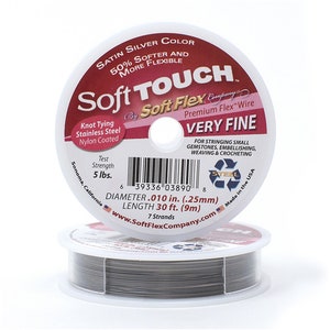 May include: Two spools of Soft Touch Very Fine beading wire. The label reads "Satin Silver Color" and "Knot Tying Stainless Steel Nylon Coated." The wire is .25mm diameter and 9m long. The wire is for stringing gemstones, embellishing, weaving, and crocheting.