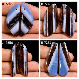 Peut inclure: Quatre paires de pendentifs en pierre gemme polis en forme de goutte, étiquetés JI-7248, JI-7249, JI-7250 et JI-7251. Chaque paire présente des motifs rayés distincts dans des tons bleu clair, brun foncé et blanc, avec un petit trou percé.
