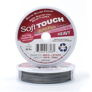 Puede incluir: Una bobina de alambre flexible Soft Touch Premium Flex Wire de color plateado satinado, etiquetada como "Heavy" y "Satin Silver Color 50% Softer and More Flexible". La bobina tiene 30 metros de largo y un diámetro de 0,61 mm. Está fabricada en los Estados Unidos y está diseñada para usarse con materiales abrasivos, piedras grandes y trabajos de lampwork.