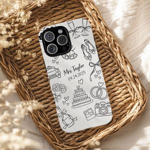 Puede incluir: Funda de teléfono blanca con un diseño de boda con contorno negro. La funda presenta ilustraciones de copas de champán, zapatos de novia, un coche, un ramo, una tarta, anillos, una cámara y una botella de champán. También se incluye el texto "Mrs Taylor 04.24.2025".