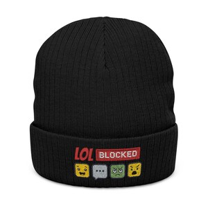 May include: Black knit beanie with the embroidered text "LOL BLOCKED" in red and white. Below the text are four emoji faces: smiling, thinking, sad, and angry. The beanie is ribbed.