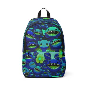 Può includere: Uno zaino blu e verde con un motivo di creature dei cartoni animati con i denti. Le creature sono circondate da fiori verdi.